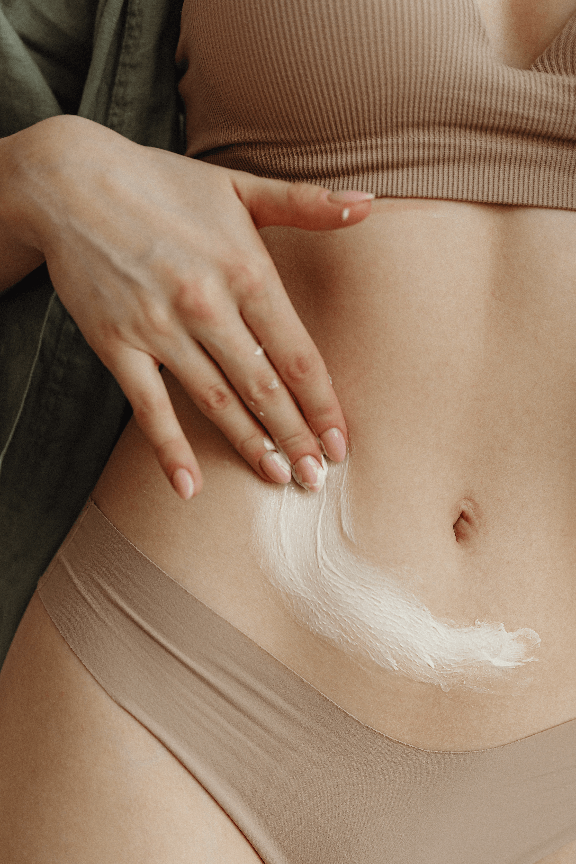 Woman rubbing ointment on her abdomen