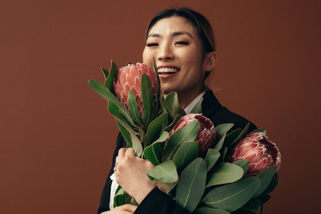 Smiling woman holding flowers.